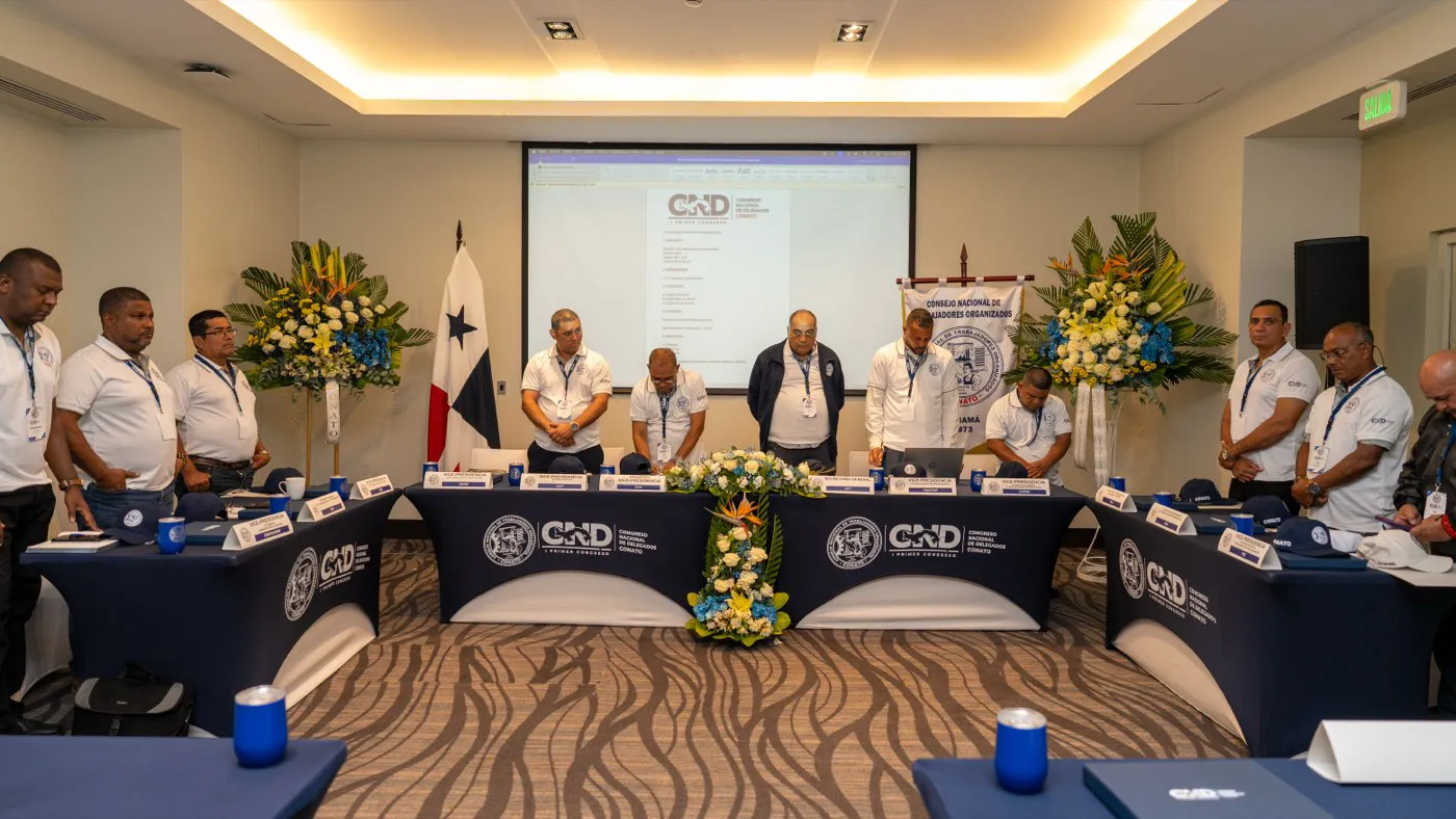 Mesa directiva y delegados de pie al inicio del congreso
